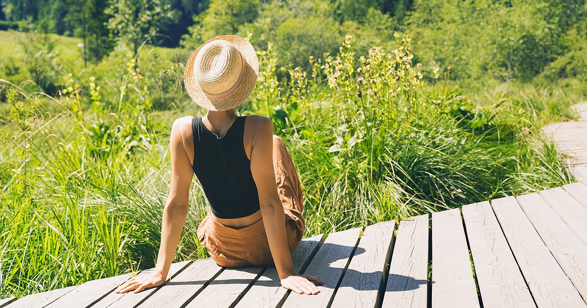 Resilience Helps Overcome Stress Woman sitting on deck overlooking landscape.